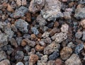 Natural brown, black and red Volcanic Lava small stones close up with a lady bug in the middle from the top of Mt. Etna background Royalty Free Stock Photo