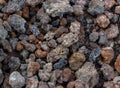 Natural black and red Volcanic Lava small stones close up with a lady bug in the middle from the top of Mt. Etna background Royalty Free Stock Photo