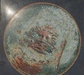 close up of god designed inside a large circle poster from the ancient villa romana del casale background