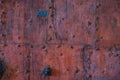 Old damaged grunge decorated faded reddish brown historic wooden door with bolts, handles and latch background