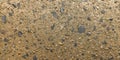 Pebble-studded concrete surface featuring a mix of small, irregularly-shaped stones in shades of grey, tan, and brown Royalty Free Stock Photo