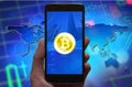 Bitcoin concept wallpaper. Cryptocurrency Bitcoin symbol at smartphone screen, phone in the hand.