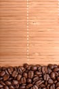 Background of bamboo mat sprinkled around the edges of fried grains coffee, space for text Royalty Free Stock Photo