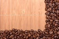Background of bamboo mat sprinkled around the edges of fried grains coffee, space for text Royalty Free Stock Photo