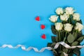 Background for banners, beautiful boquet of white roses ribbon an isolated blue background with copyspace. Flatlay. Spring concept Royalty Free Stock Photo