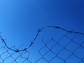 Background of a barbwire fence against a blue sky Royalty Free Stock Photo