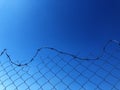 Background of a barbwire fence against a blue sky Royalty Free Stock Photo