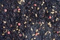 Background of black fruit tea with dried ginger and pieces of pink candied pineapple