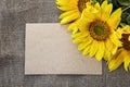 Background with blank card and sunflowers on canvas burlap. Space for text.