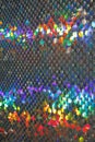 The background of blisters close-up shimmers with iridescent colors. Texture of sequins