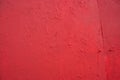 Background of blood-red colored plaster with cracks on concrete wall. Dark-red stucco decorative wall coating