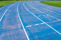 background of blue track for running competition at stadium, focus on center Royalty Free Stock Photo