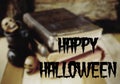 Background blur for Halloween in October includes old worn books, miniature skulls and cauldrons on a wooden table