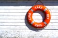 Background, blur, out of focus, bokeh. Orange rescue float. Lifebuoy on the wall of the building of the rescue station