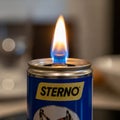The background is blurred focusing attention on the can and its flame Royalty Free Stock Photo