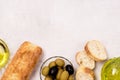 Background with Bowls with Green and Black Olive Olive Oil Artisan Bread Mediterranean Food Light Gray Background Copy Space