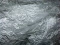 Background cellophane texture on a black background. Abstract background of a plastic bag. Crumpled plastic bag close-up. Royalty Free Stock Photo