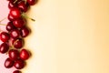 Cherry berries on a yellow background top view.Background with a cherry on a sprig, flat lay. Royalty Free Stock Photo