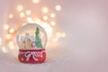 Background for a Christmas card in light pink with a souvenir snow globe Royalty Free Stock Photo