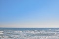 Background, clear blue sky, sea, waves crashing on the shore, seagulls flying low over the sea Royalty Free Stock Photo