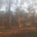 Background, close-up of small raindrops, blurred country landscape with backlight. Royalty Free Stock Photo