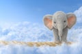 With the background colored blue, a baby elephant is seen walking on a tightrope Royalty Free Stock Photo