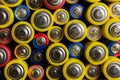 Background of colorful batteries. Close up top view on rows of selection of batteries. Many alcaline batteries. Macro.