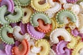 Background of colorful green, yellow, white, orange and pink italian crown pasta, close-up