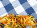 Background of colorful pasta texture close-up. close up of a dried italian pasta onblue plaid tablecloth. Royalty Free Stock Photo