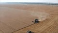 New harvesters on the field collect wheat. Panoramic view on the field of collected wheat. On the background the combine harvester