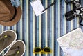 Background composition from above for summer holidays with vintage camera, sunglasses, flip-flops, straw hat, map and notepad with