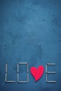 Background of concrete and blue paint plaster. On the texture matches arranged in the form of the word Love. In the middle o