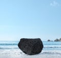 Background for cosmetic products on beach with sand. Natural volcanic rock stone podium. Empty showcase for packaging