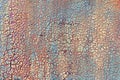 Background of cracked multilayer paint on a rusty metal wall. Small texture.