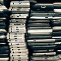 Background of damaged mobile phones. A bunch of broken smartphones. Used phones stacked on top of each other. Repair services and