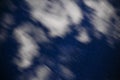 Background of dark-blue night sky with countless twinkle stars and moving white clouds upon on it Royalty Free Stock Photo