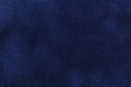 Background of dark blue suede fabric closeup. Velvet matt texture of navy blue nubuck textile