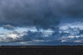Background of dark clouds before a thunder-storm over late autumn fields and forest Royalty Free Stock Photo