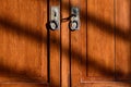 Background, detail and close-up of an old wooden cabinet, with metal handles and an old key. On the surface are dark streaks of a Royalty Free Stock Photo