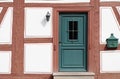 Background and detail shot of the facade of a half-timbered house in Germany, Bavaria. You can see the green wooden door, the