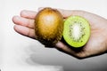 Healthy eating and diet Topic: Human hand holding a half kiwi isolated on a white background in the studio Royalty Free Stock Photo