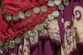 Background of draped gypsy shawls with decorative coin and bead fringe and distinctive weave for each piece - red and burgundy