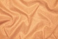 Background of draped light orange fabric with silver lurex thread