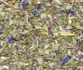 Background of dry leaves of herbal tea with petals of mountain flowers in a macro. Loose herbal tea texture