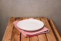 Background with empty plate on tablecloth and wooden table Royalty Free Stock Photo