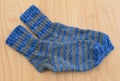 Background feet gray and blue knit a pair of sheep socks thick warm white winter wool. Royalty Free Stock Photo