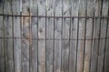 Background of the fence gray boards with knots hammered metal tape barbed wire