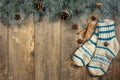 Background with fir branches and a set of Christmas decorations on a dark wooden background. Wool socks, fir branches, cones and