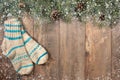 Background with fir branches and a set of Christmas decorations on a dark wooden background. Wool socks, fir branches, cones and