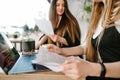 Background. Focus on a hands. Close up.Two businesswomen sit in cafe with business papers in hands and laptop and discuss business